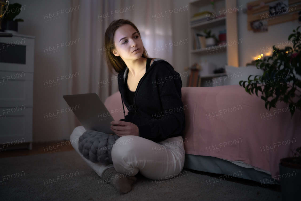 Worried young girl with laptop sitting and smiling, online dating and internet abuse concept.