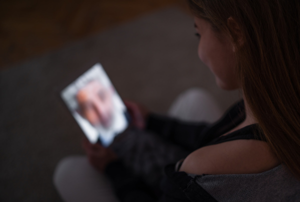 Unrecognizable happy young girl with laptop at night smiling, online dating concept.