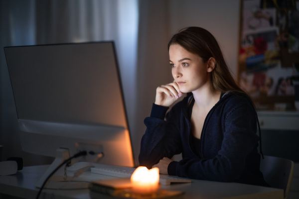 Beautiful happy young girl with laptop sitting and smiling, online dating and chatting concept.