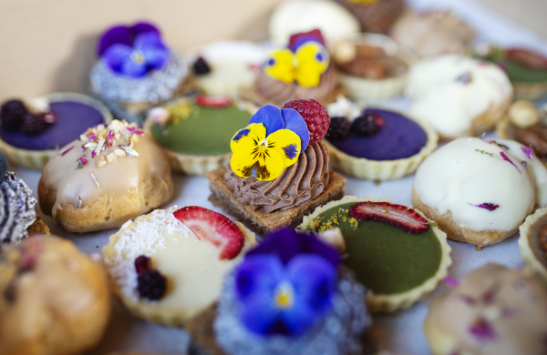 A selection of colorful and delicious cake desserts in box on table.