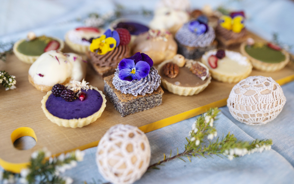 A selection of colorful and delicious cake desserts on tray on table.