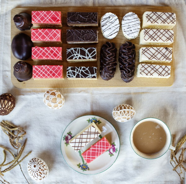 A top view of selection of colorful and delicious cake desserts on tray on table.