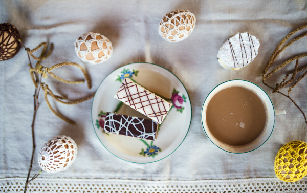 A top view of delicious cake desserts and coffee on table, Easter decorations.