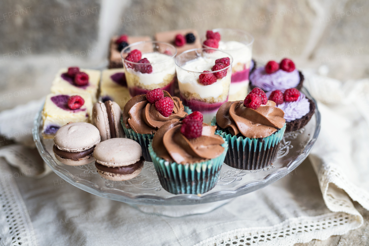 A selection of colorful and delicious cake desserts on tray on table.