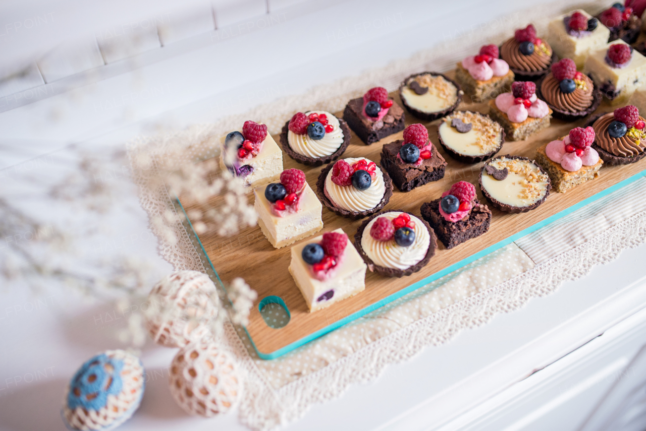 A selection of colorful and delicious cake desserts on tray on kitchen counter.