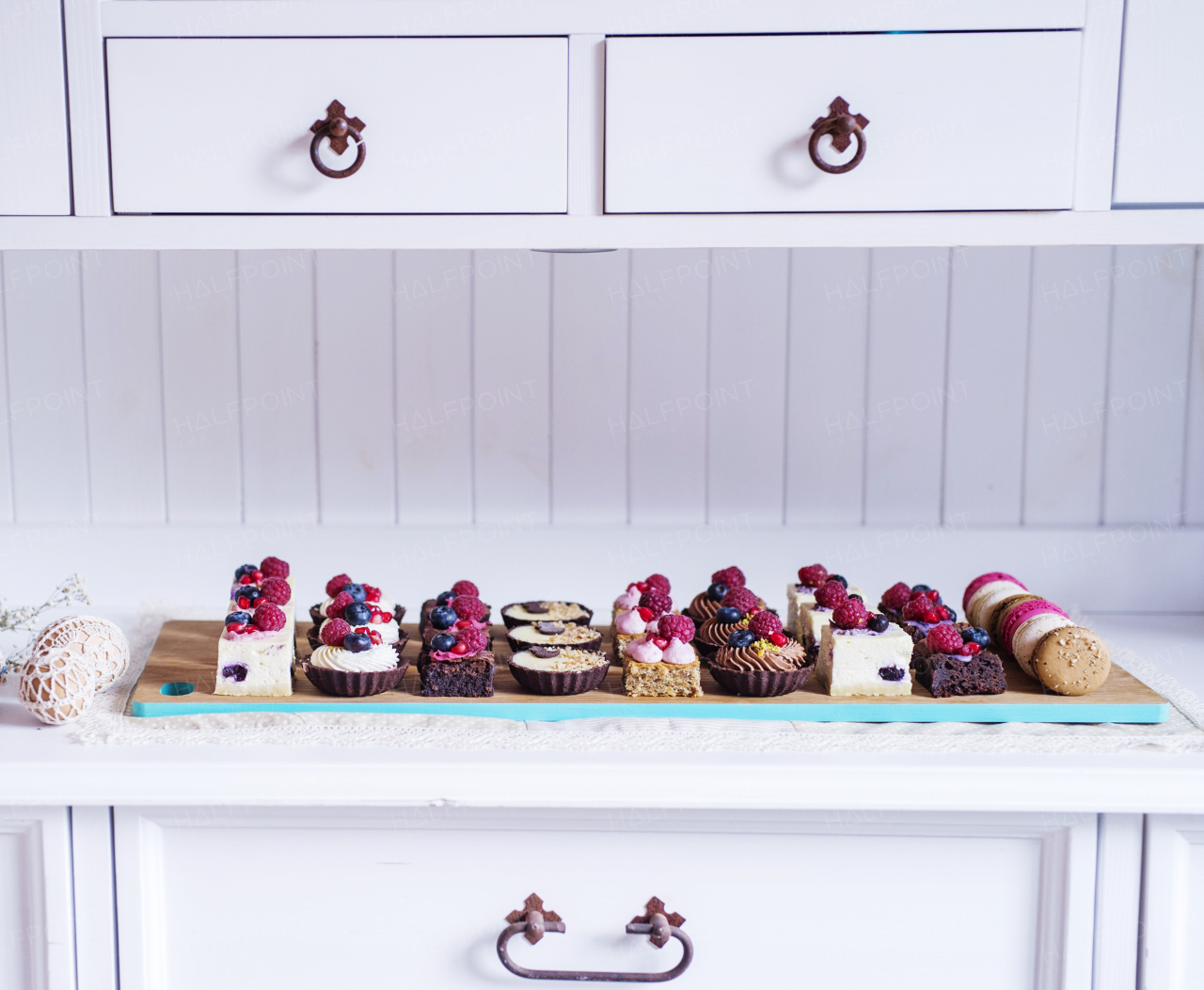 A selection of colorful and delicious cake desserts on tray on kitchen counter.