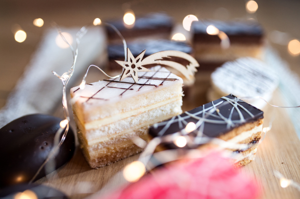 Selection of colorful and delicious cake desserts on a rusty wooden table.