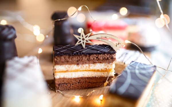 Selection of colorful and delicious cake desserts on a rusty wooden table.