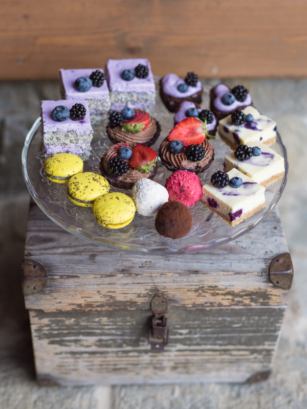 Selection of colorful and delicious cake desserts on a rusty wooden box.