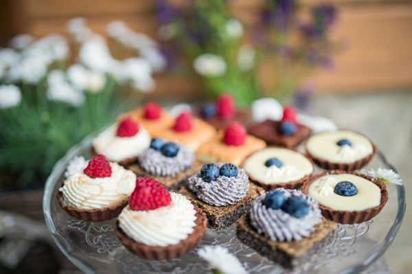 A selection of colorful and delicious cake desserts on tray on table.