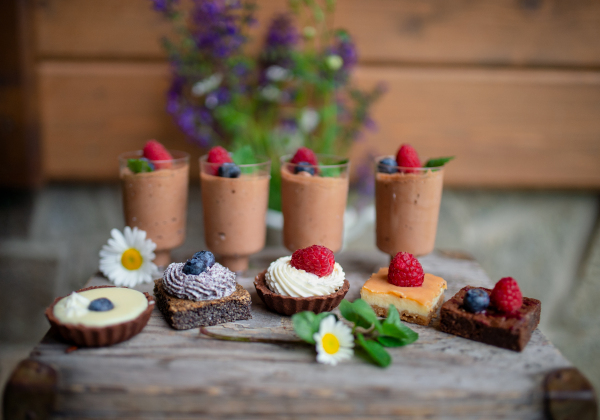 Selection of colorful and delicious cake desserts on a rusty wooden box.