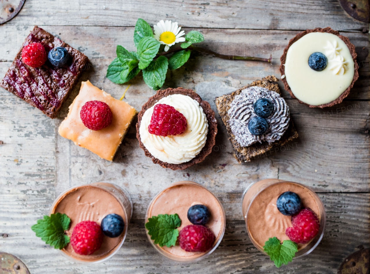 A selection of colorful and delicious cake desserts on wooden table.