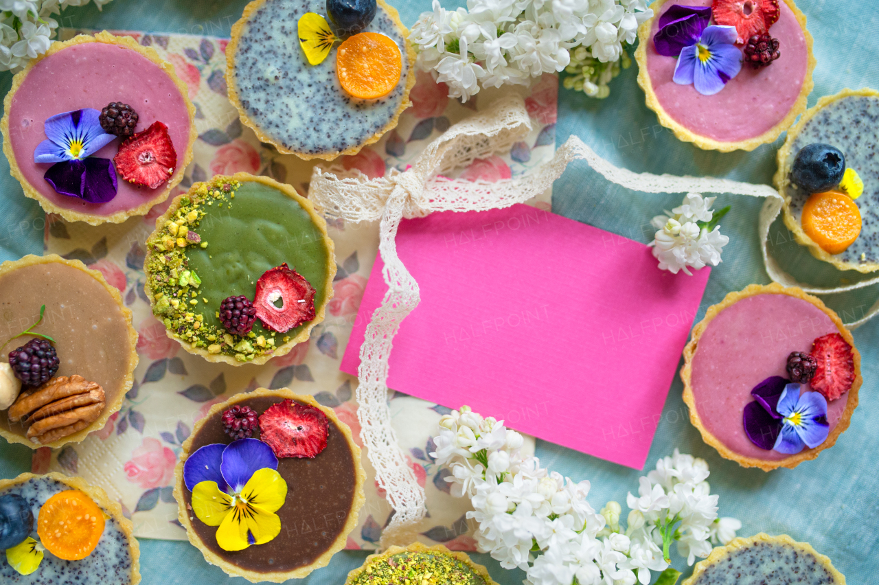 A top view of selection of colorful and delicious cake desserts in box on table. Copy space.