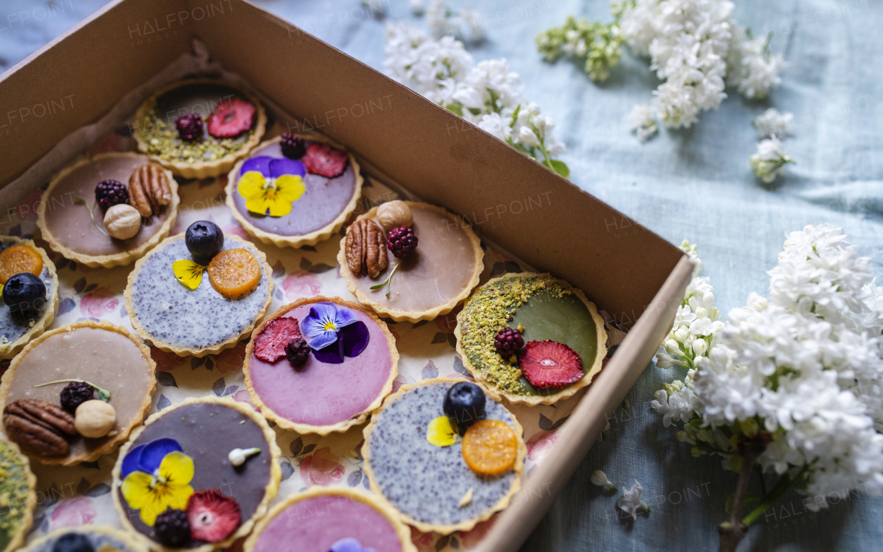 A top view of selection of colorful and delicious cake desserts in box on table.