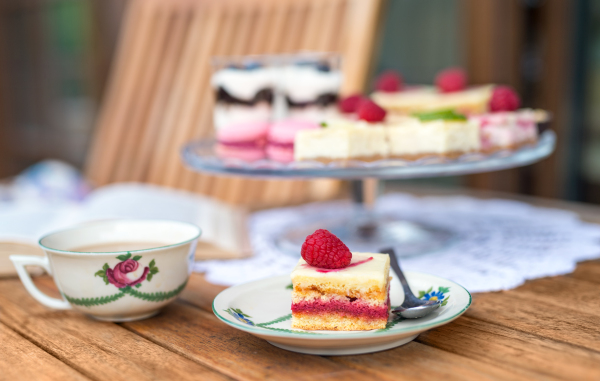 A cup of coffee and desserts on table, close-up.