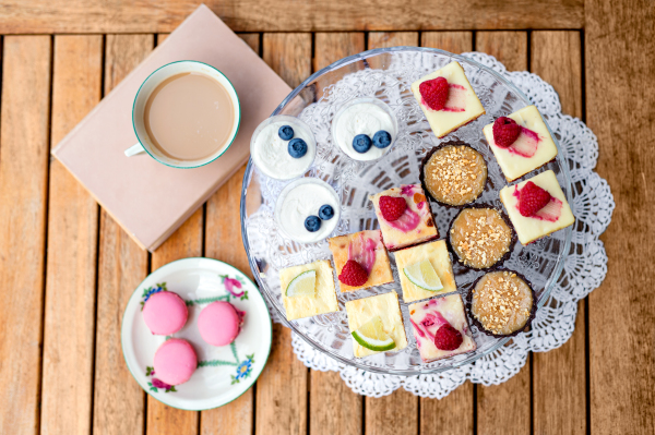 A cup of coffee and desserts on table, top view.