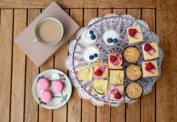 A top view of selection of colorful and delicious cake desserts on tray on table.