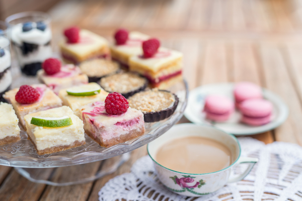 A cup of coffee and desserts on table, close-up.