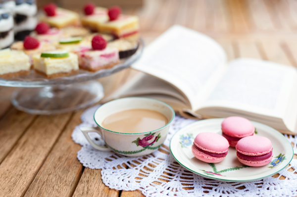 A cup of coffee and desserts on table, close-up.