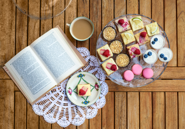 A top view of selection of colorful and delicious cake desserts on tray on table.