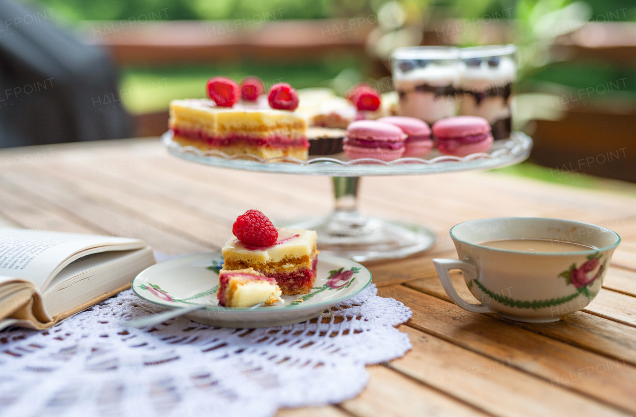 A cup of coffee and desserts on table, close-up.