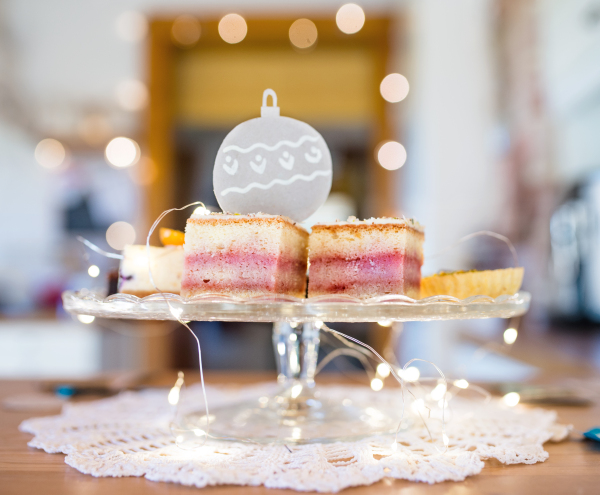 A selection of delicious cake desserts on tray, Christmas lights decorations.