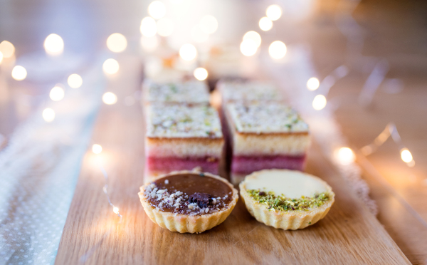 Selection of colorful and delicious cake desserts on a rusty wooden table.