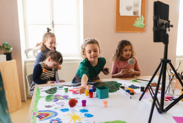 A group of little kids working on project during creative art and craft class at school.