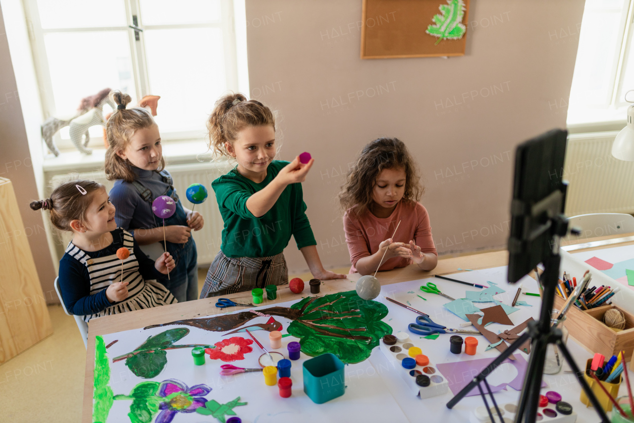 A group of little kids working on project during creative art and craft class at school.