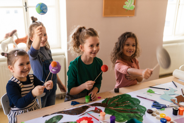 A group of little kids working on project during creative art and craft class at school.