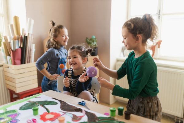 A group of little kids working on project during creative art and craft class at school.