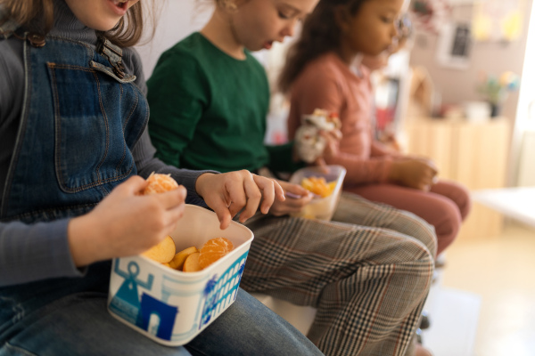 A group of classmates having fruit snack during break at school.