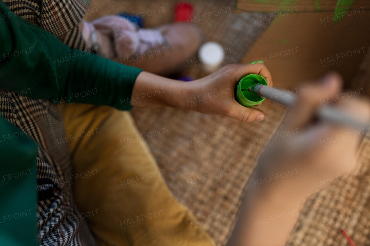 A close-up of little girl painting with brush during art class.