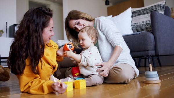 A happy multigeneration family playing with small baby indoors at home, visiting concept.