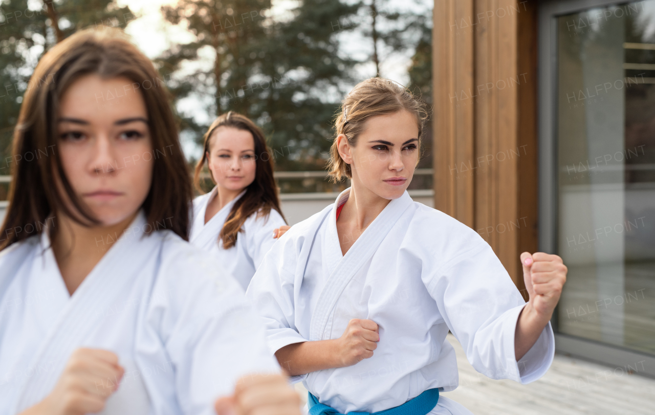 A group of young women practising karate outdoors on terrace.