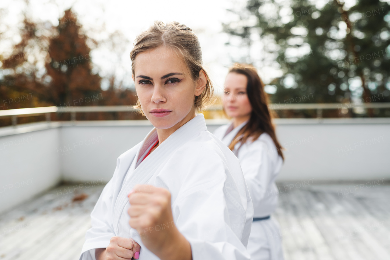 A group of young women practising karate outdoors on terrace.