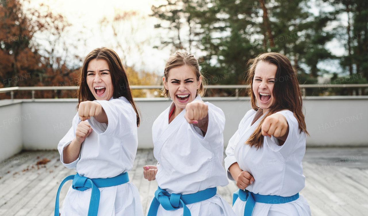 A group of young women practising karate outdoors on terrace.