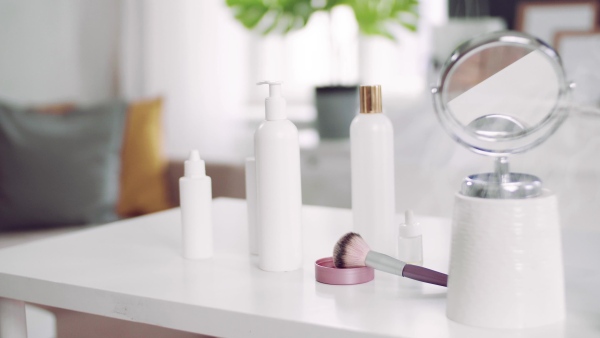 A close-up of mirror and beauty products on the desk.