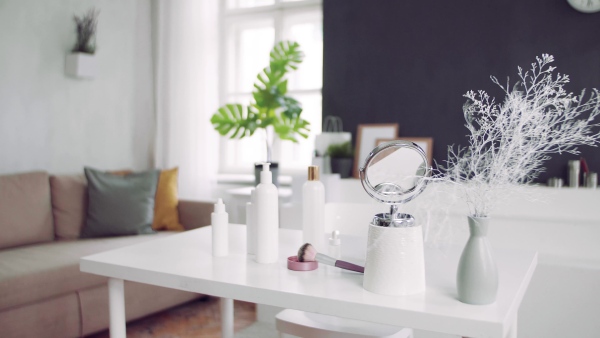 A mirror and beauty products on the desk.