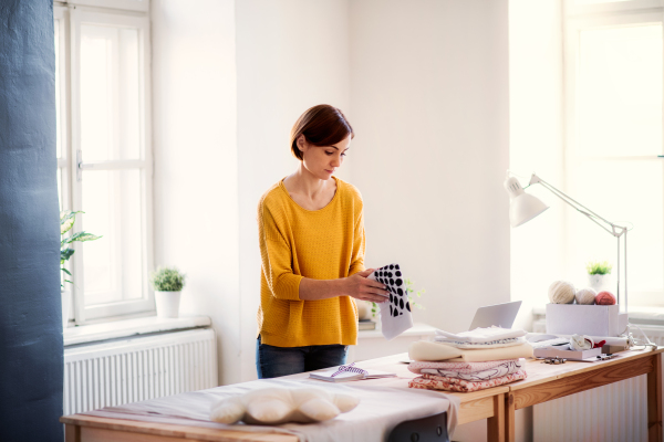 Young creative woman working in a studio, startup of small tailoring business.