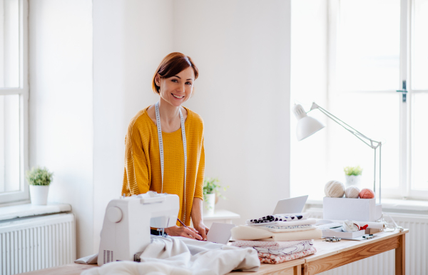 Young creative woman working in a studio, startup of small tailoring business.