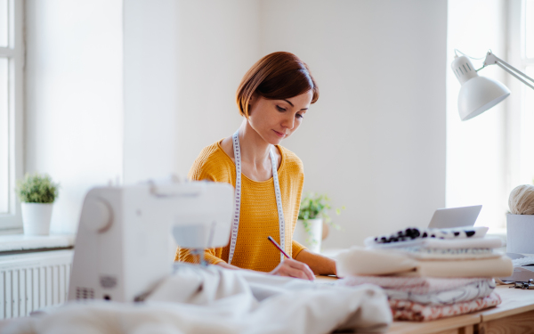 Young creative woman working in a studio, startup of small tailoring business..