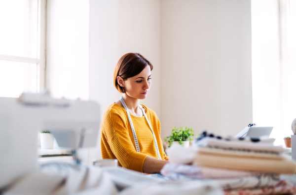 Young creative woman working in a studio, startup of small tailoring business..