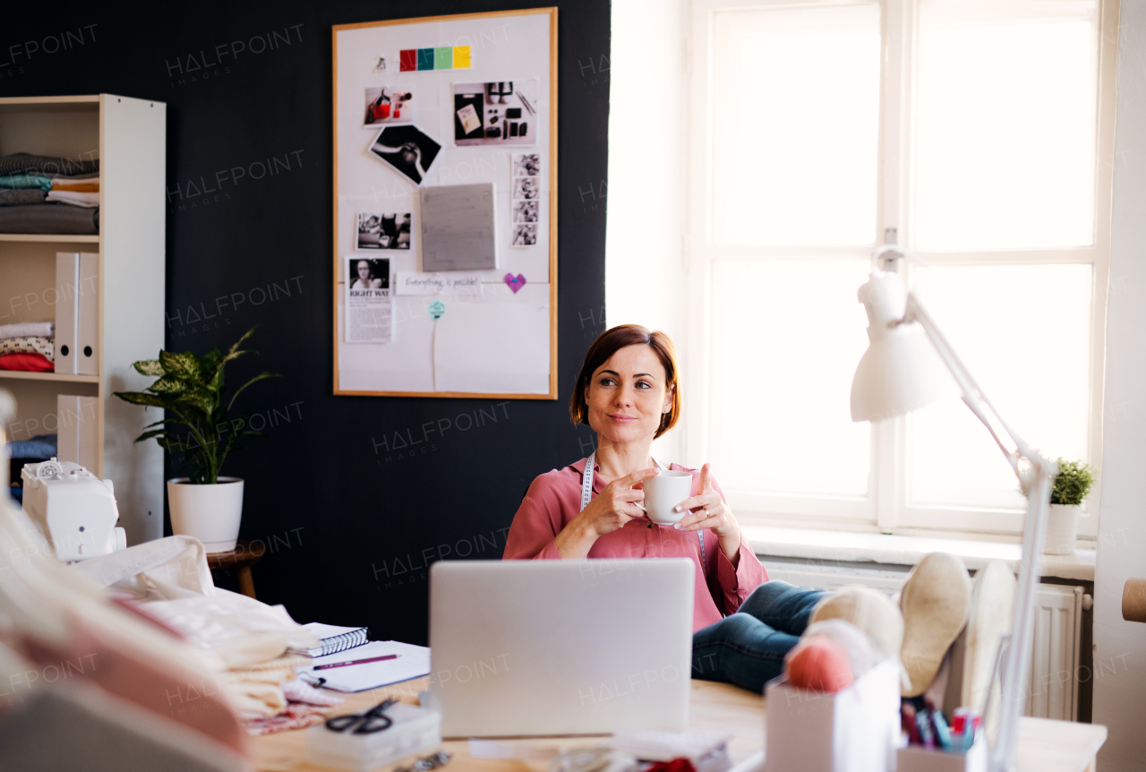 Young creative woman in a studio, resting. A startup of small tailoring business.