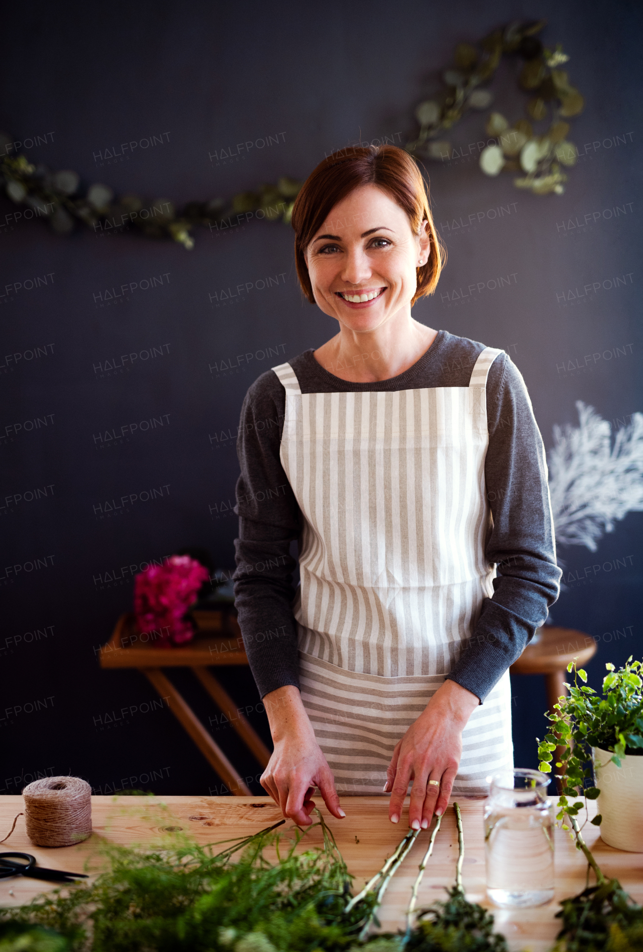 A young creative woman arranging flowers in a flower shop. A startup of florist business.