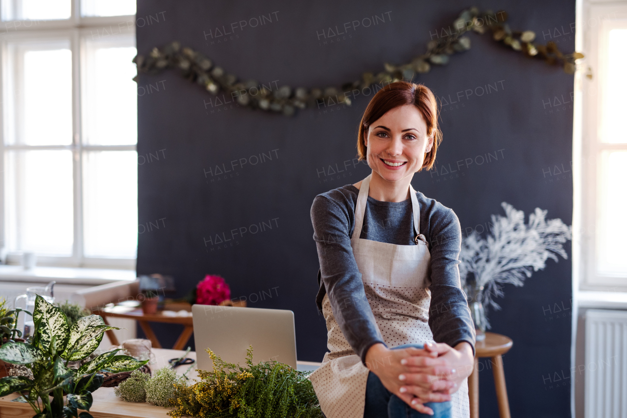 A young creative woman arranging flowers in a flower shop. A startup of florist business.