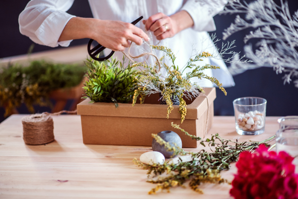 A midsection of young creative woman working in a flower shop. A startup of florist business.