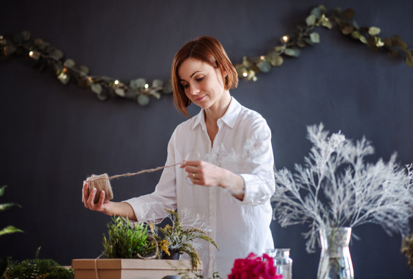 A young creative woman arranging flowers in a flower shop. A startup of florist business.