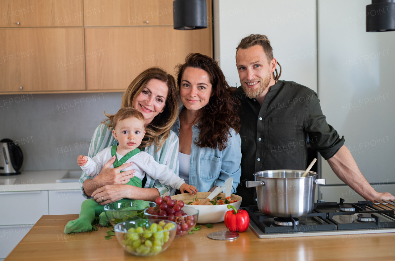 Happy multigeneration family indoors at home preparing vegetable salad in kitchen.