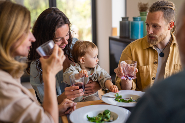 A happy multigeneration family indoors at home eating healthy lunch.